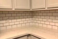 white-subway-tile-installation-as-kitchen-backsplash-in-corner-under-cabinets